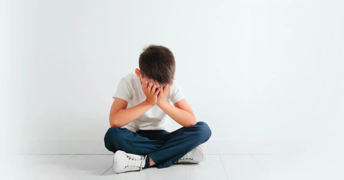 mental-health-issues-for-children Child sitting with crossed knees and head in his hands